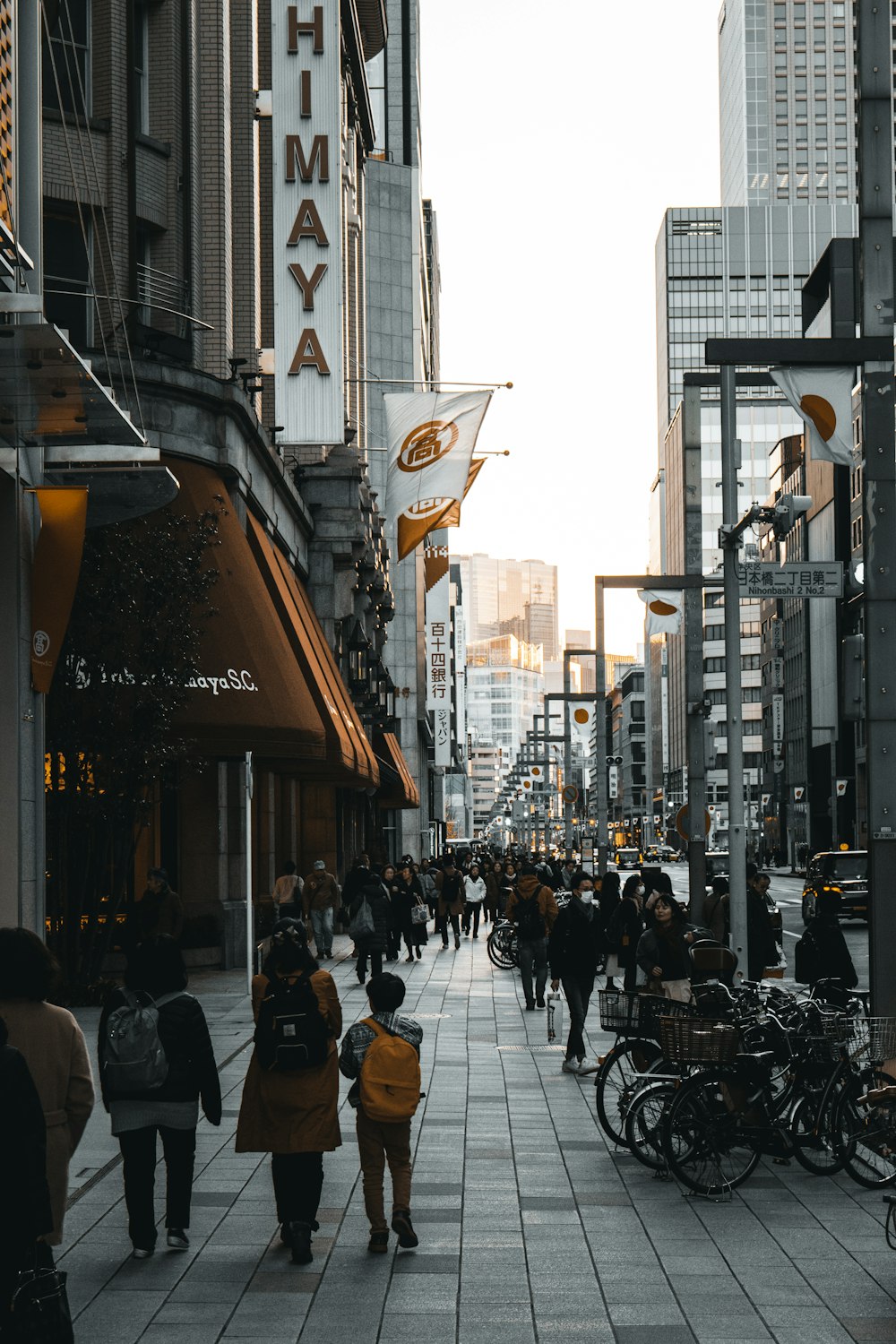 people walking on sidewalk between buildings