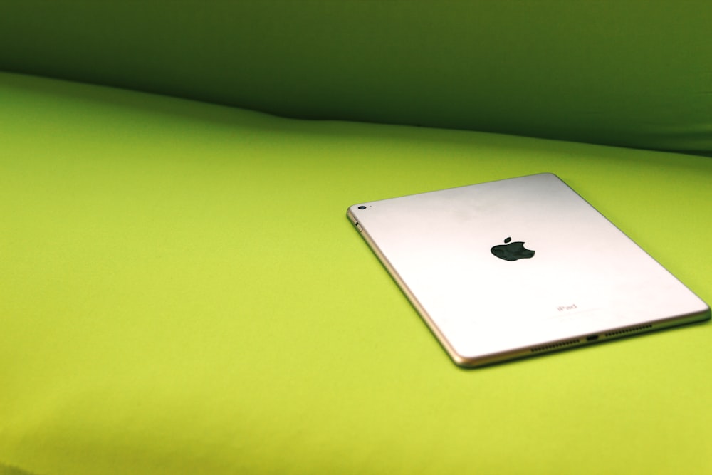 silver iPad on green surface