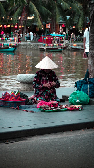 kneeling woman on placemat beside body of water