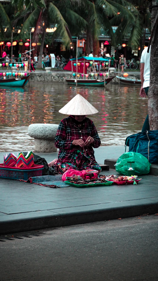 kneeling woman on placemat beside body of water