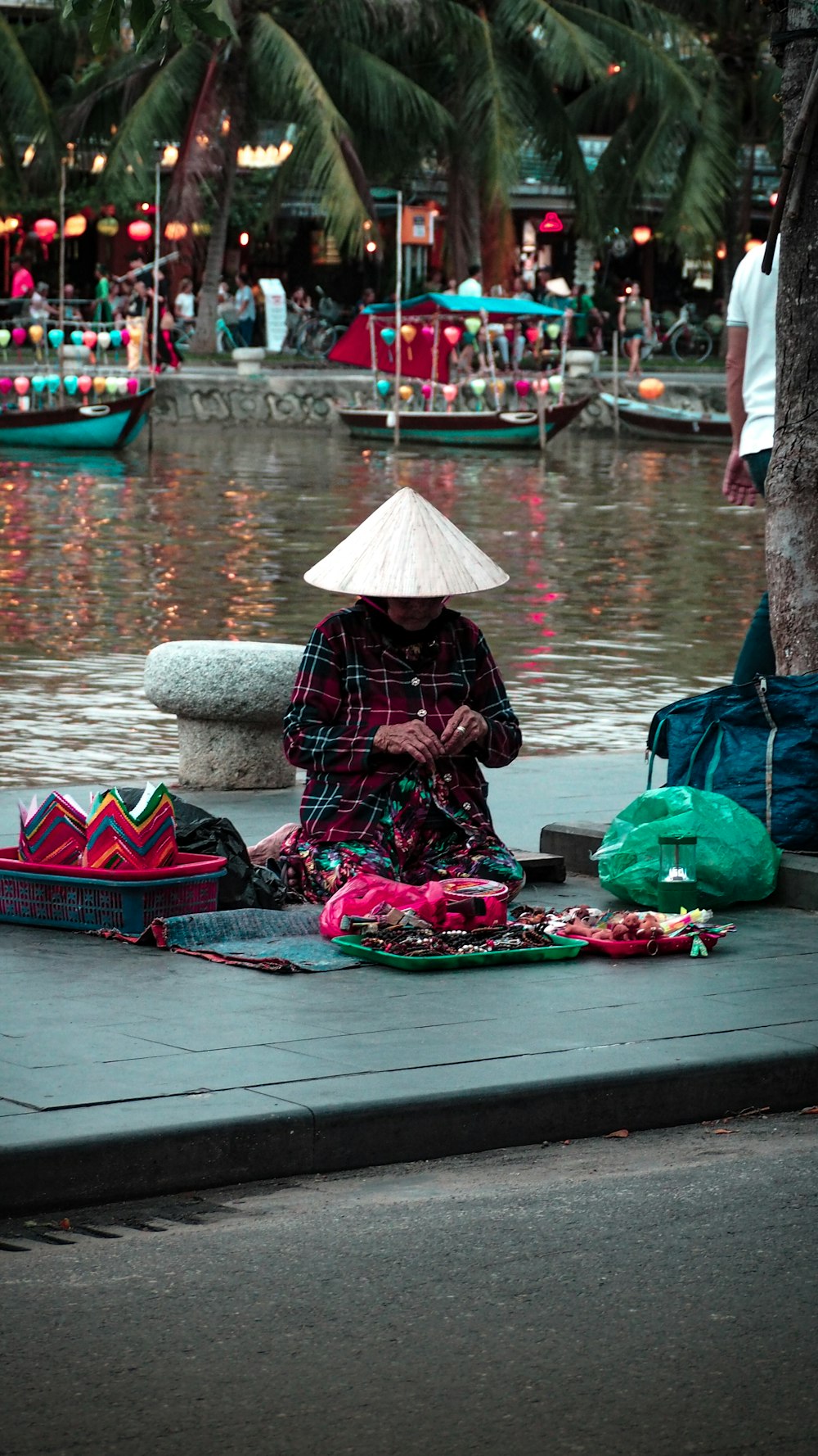 kneeling woman on placemat beside body of water