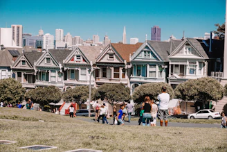 a group of people walking in front of a row of houses