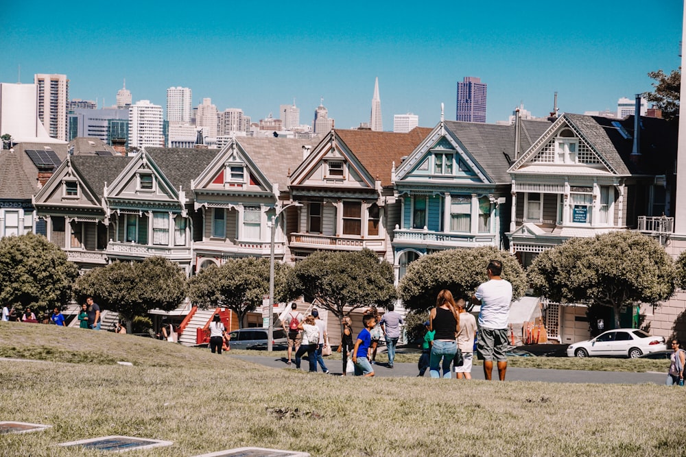 a group of people walking in front of a row of houses