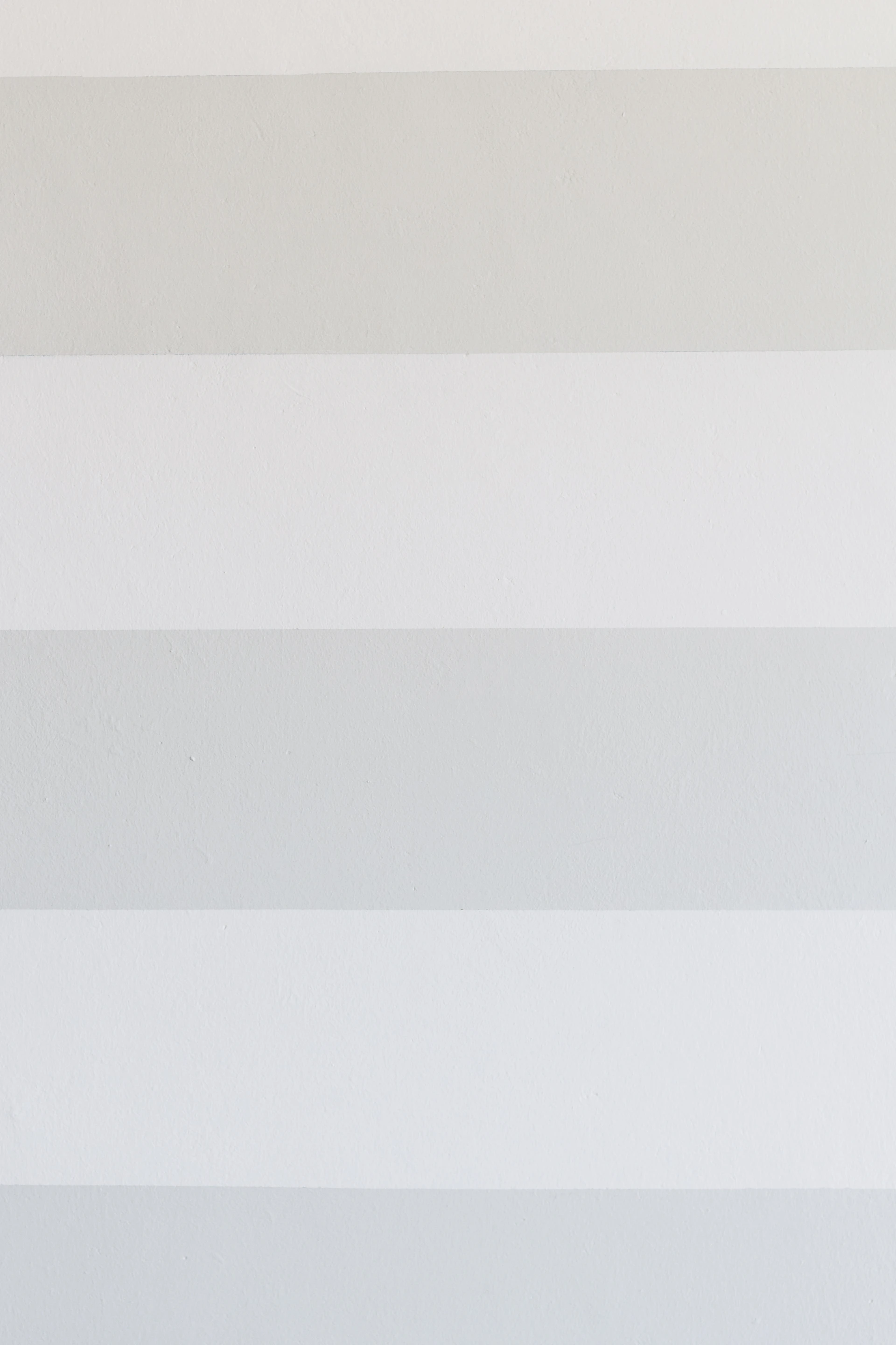 a white and gray striped wall with a clock on it