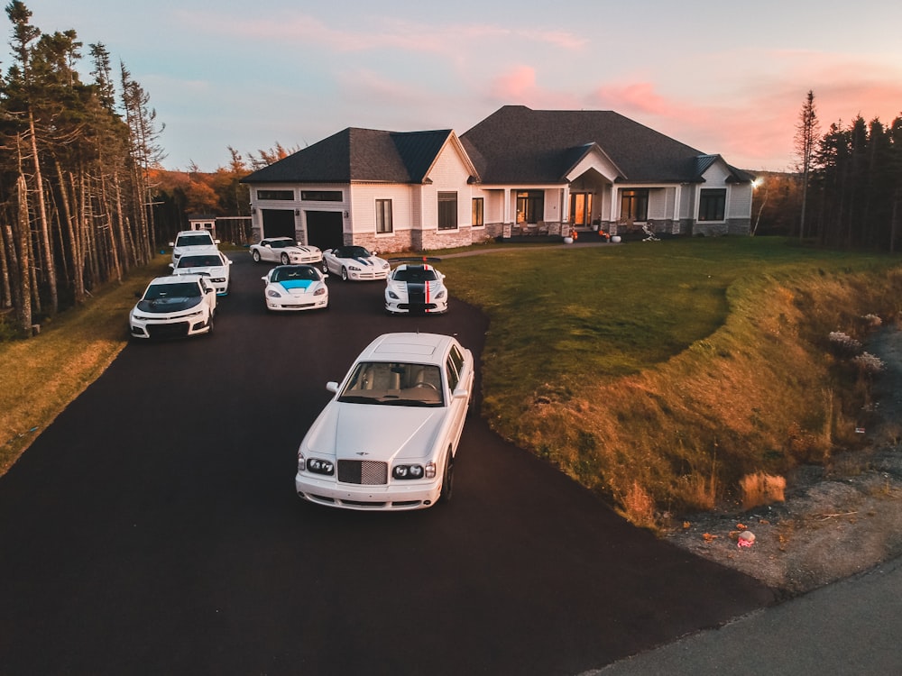 vehicles in front of white and gray house