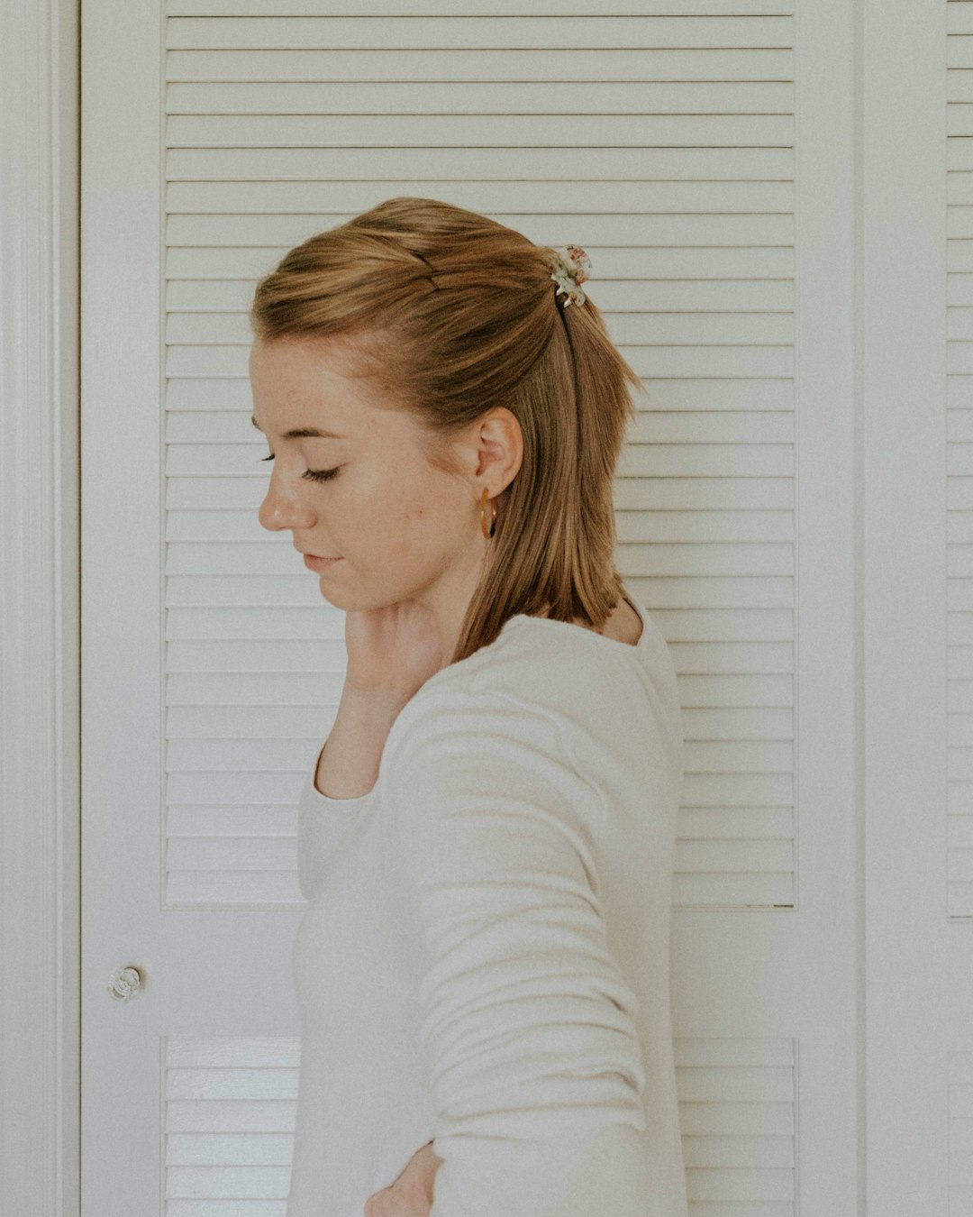 selective focus photography of woman standing beside white wooden door