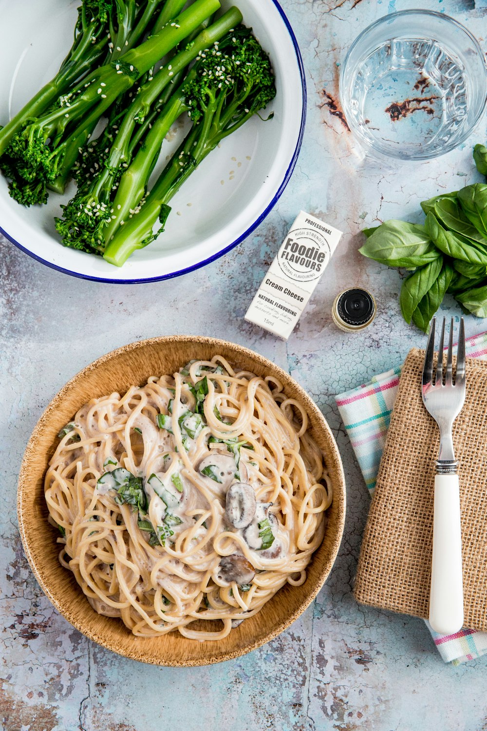 pasta in bowl near bowl of green vegetables