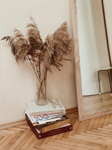 brown plants in glass vase on pile of books