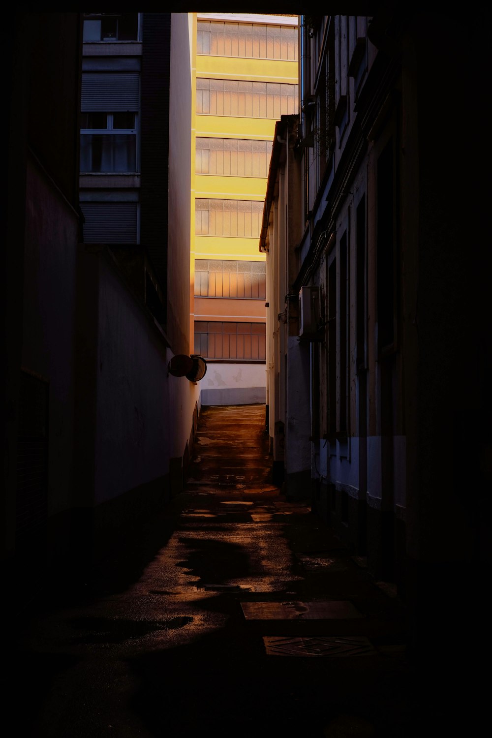 a narrow alley way with a building in the background