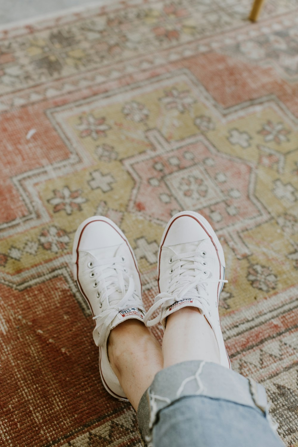 person wearing white Converse sneakers