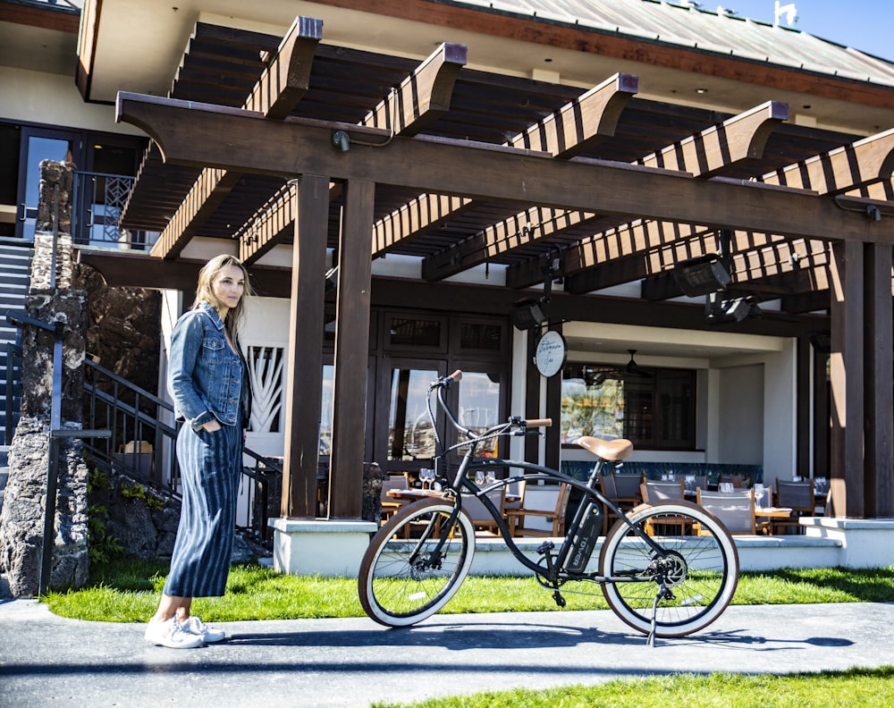 woman standing near bike outside house