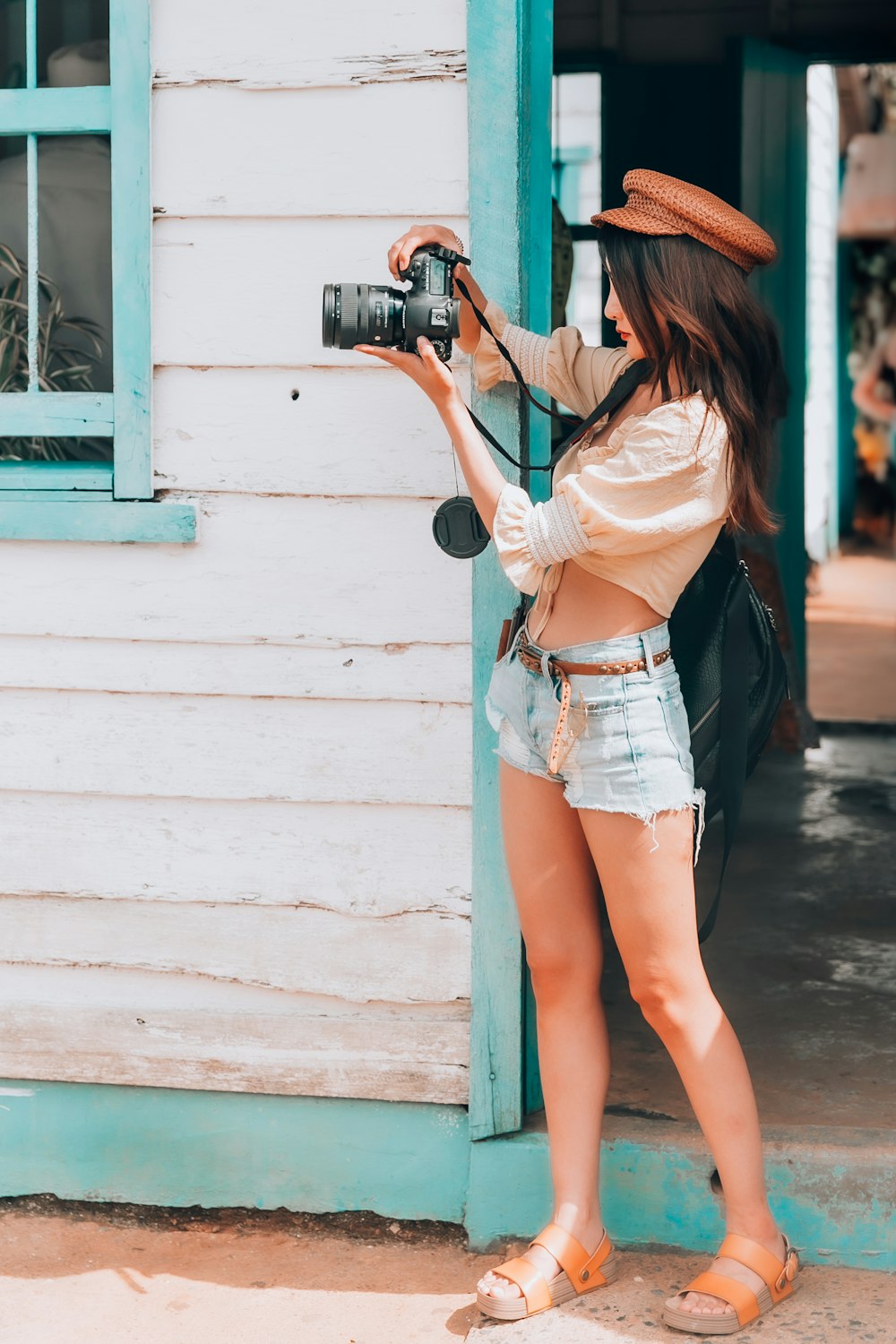 woman holding DSLR camera near door