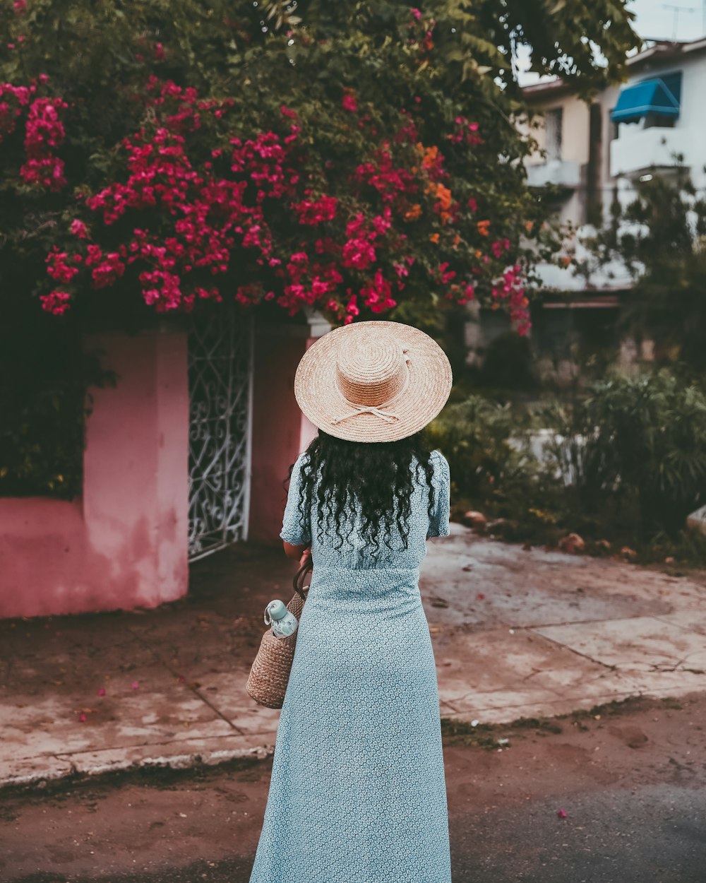 woman standing on road in front of house