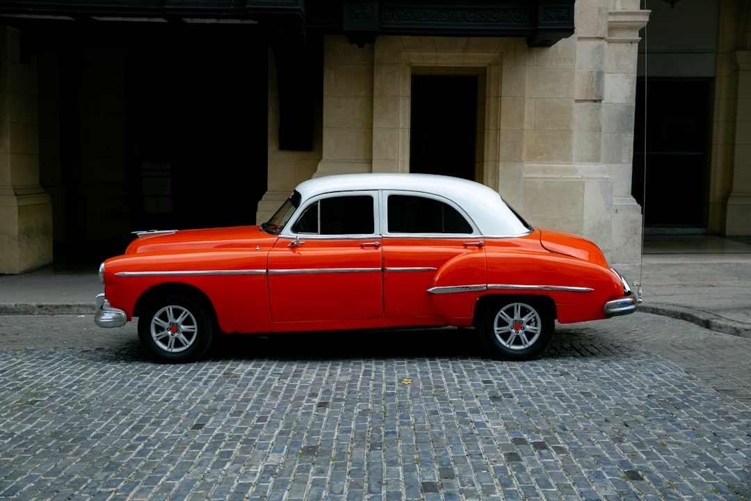 red and white four door car parked near building