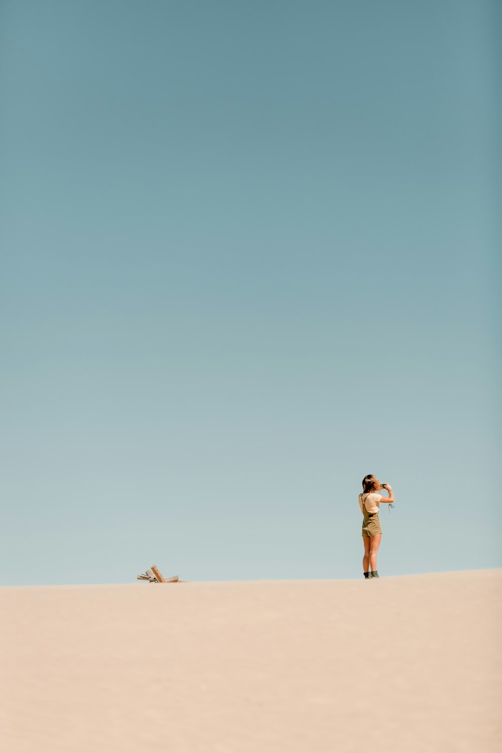 person wearing white t-shirt standing on desert during daytime