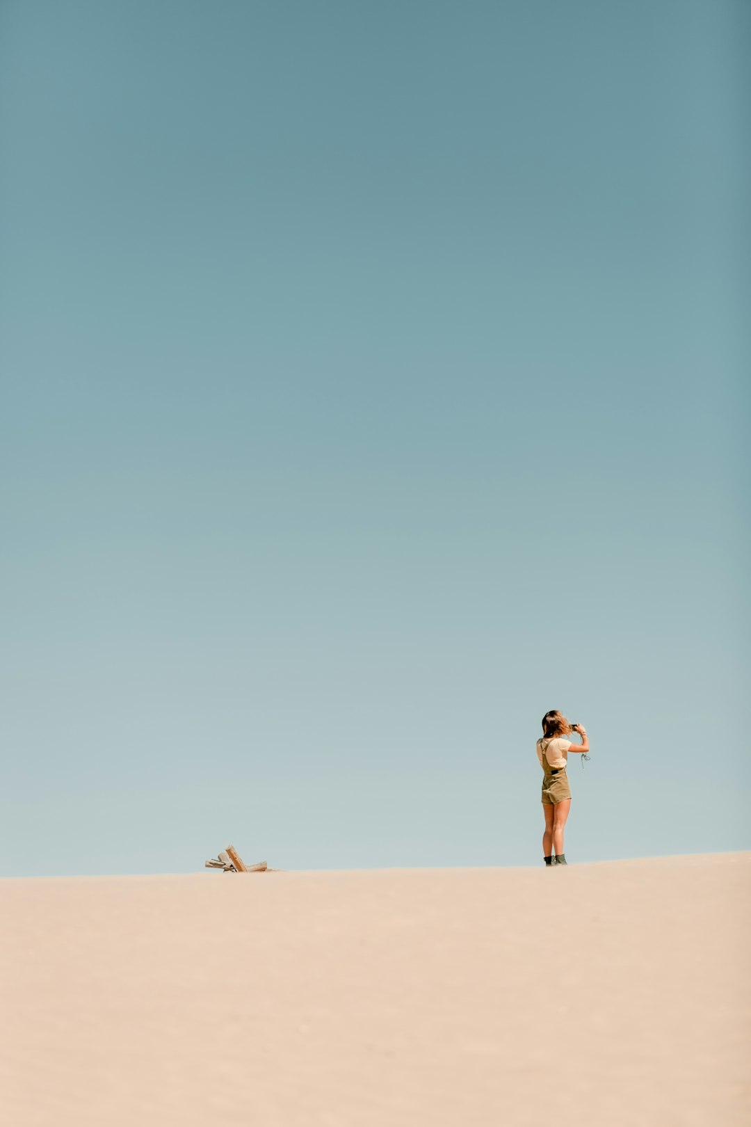 person wearing white t-shirt standing on desert during daytime