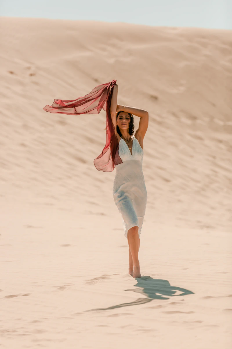 Woman in a white slip dress on sand dunes