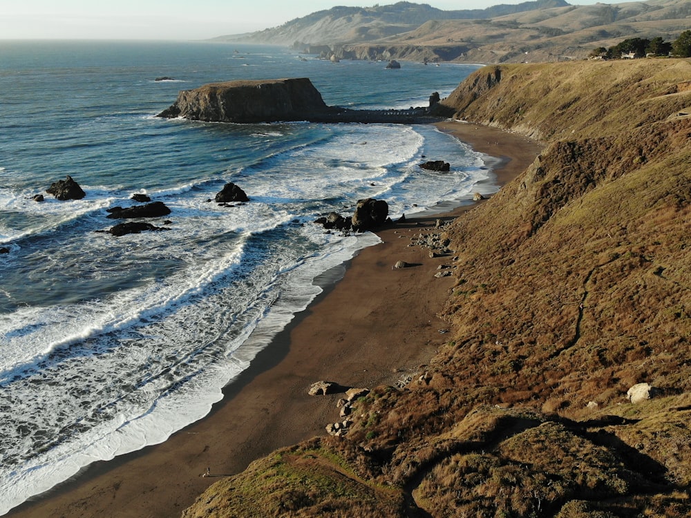 bird's eye photography of rock formation on shoreline