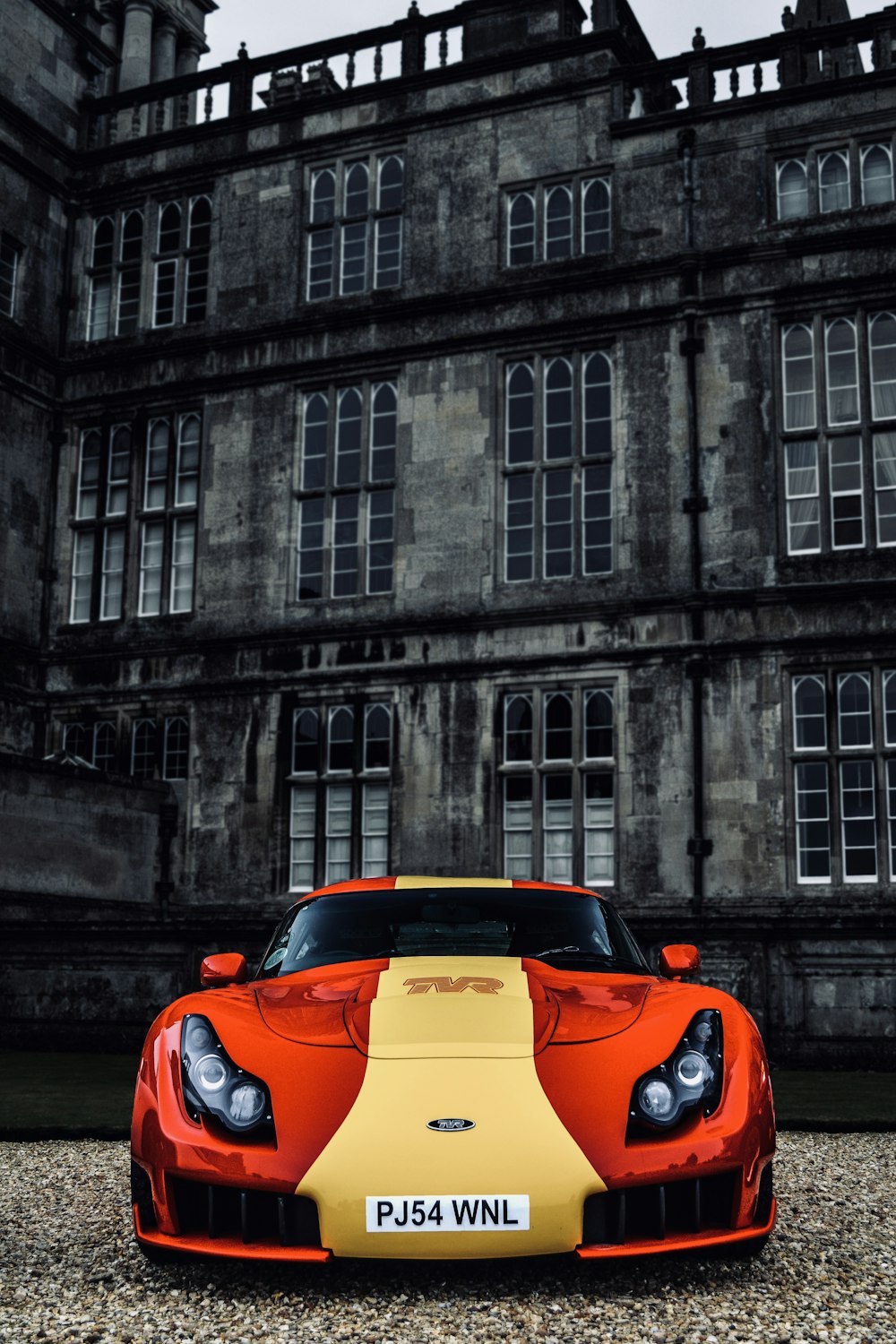 red and yellow sports car near building