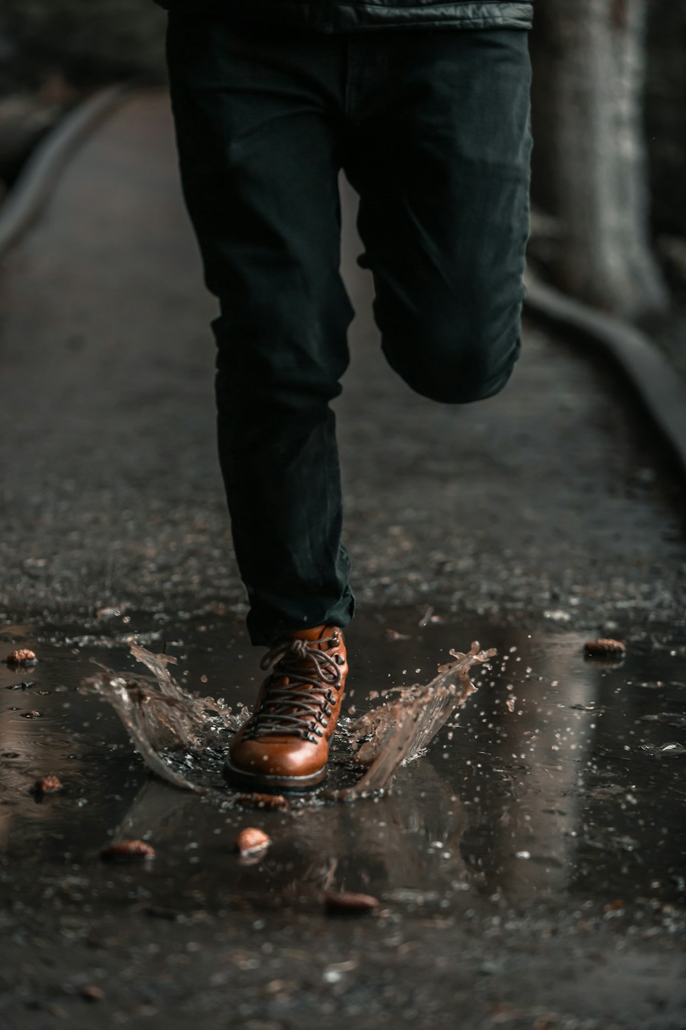 a person walking in the rain on a wet sidewalk
