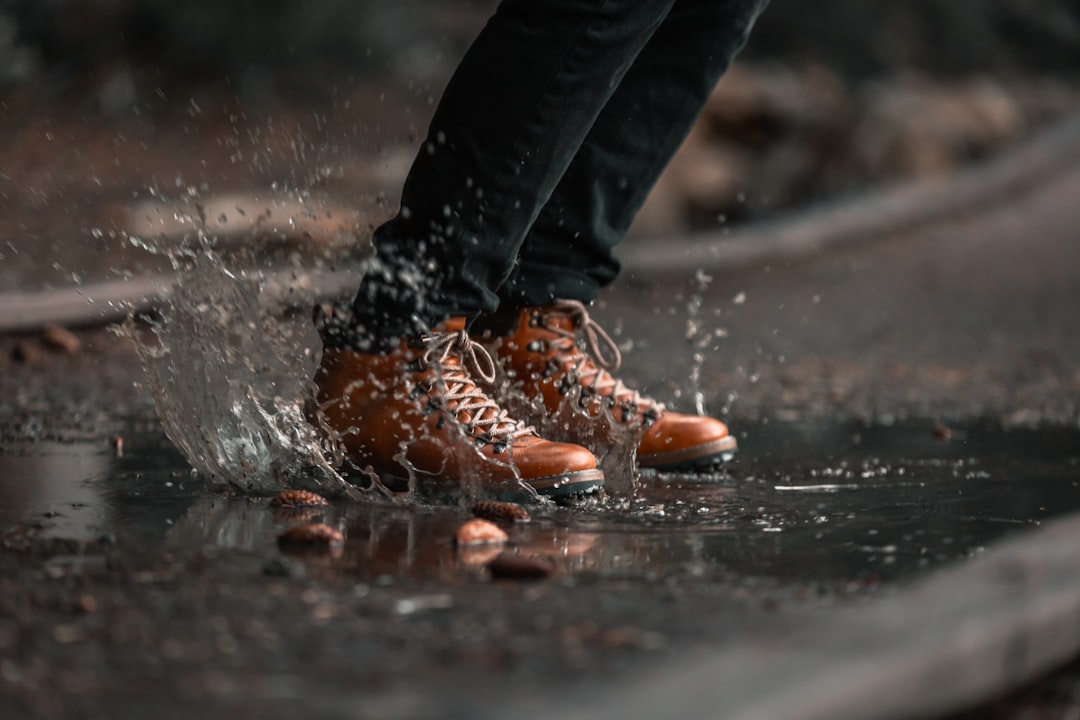 person jumping on water puddle