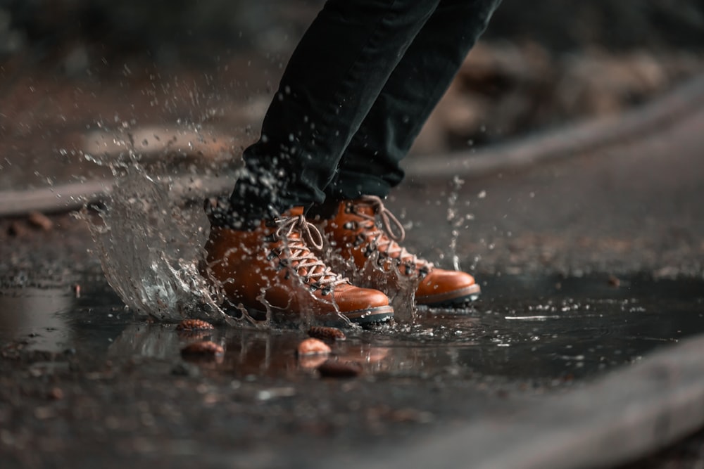 person jumping on water puddle