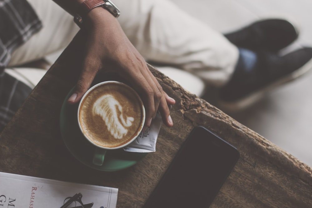 a person sitting at a table with a cup of coffee