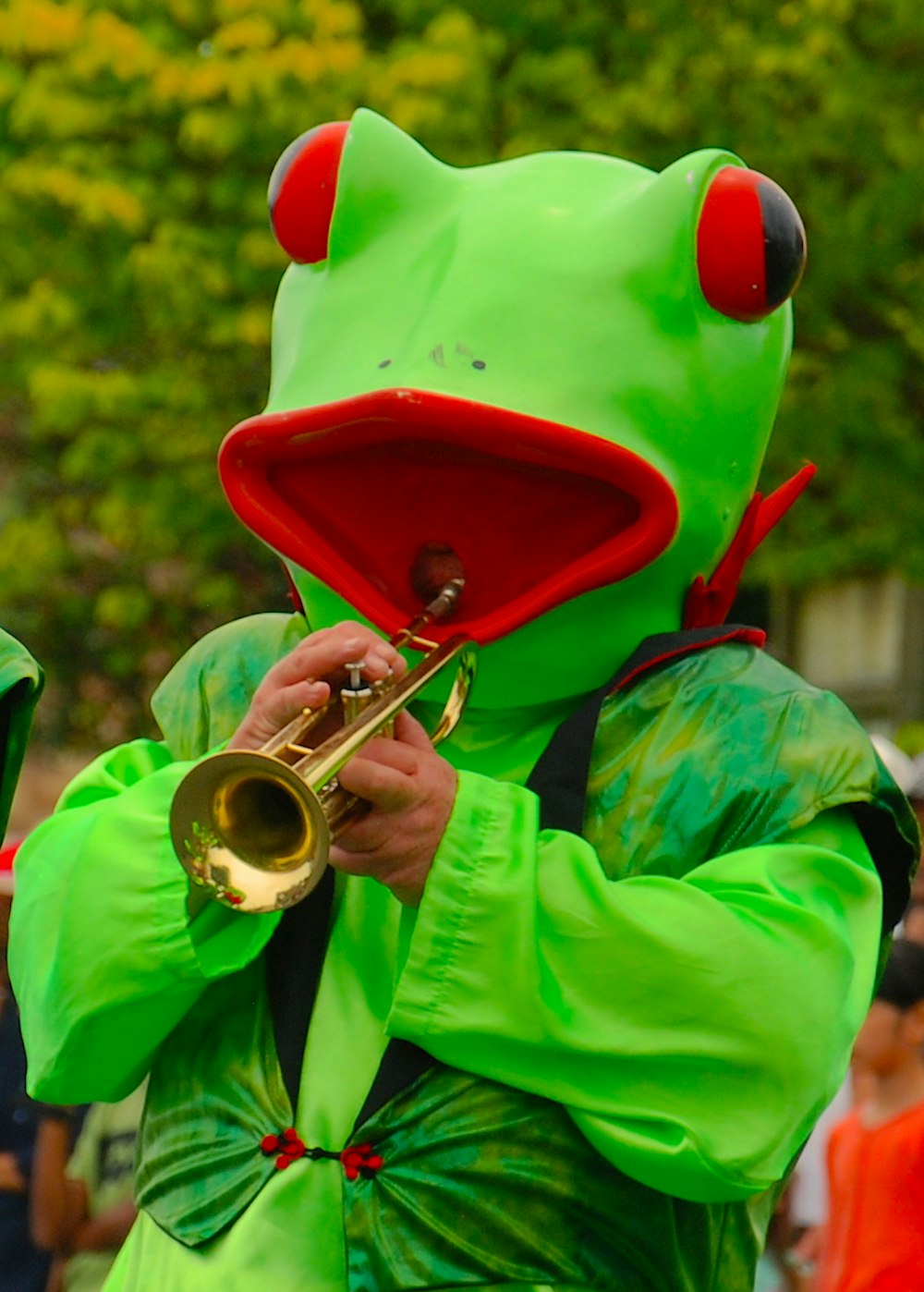 personne en costume de grenouille tout en jouant de la trompette