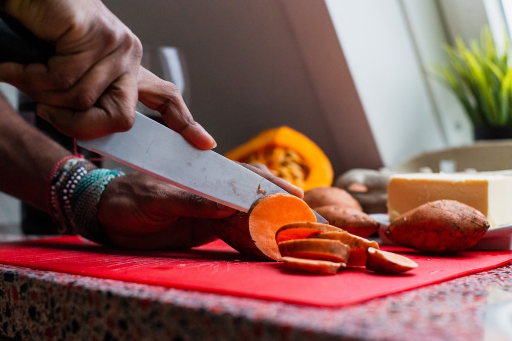 person slicing root crop