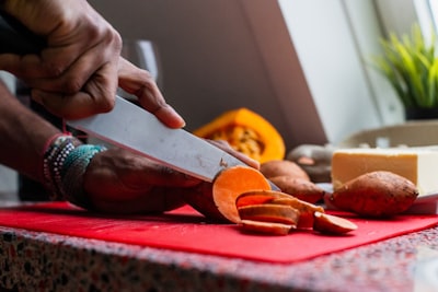 person slicing root crop sweet potato google meet background