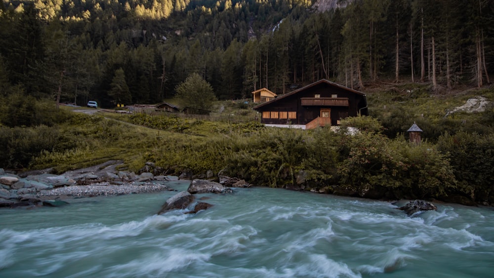 a house sitting on top of a hill next to a river