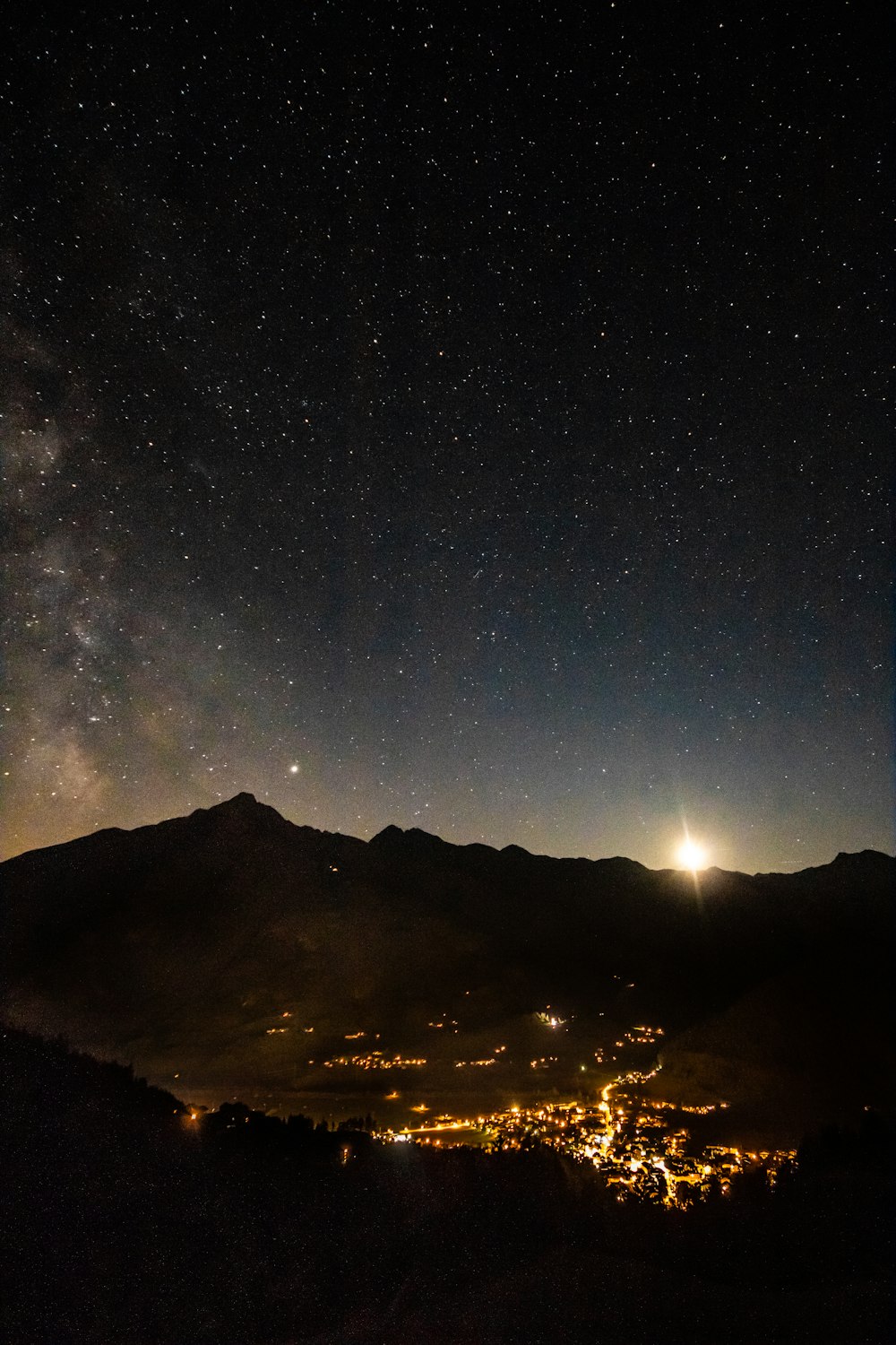 a view of the night sky from a hill