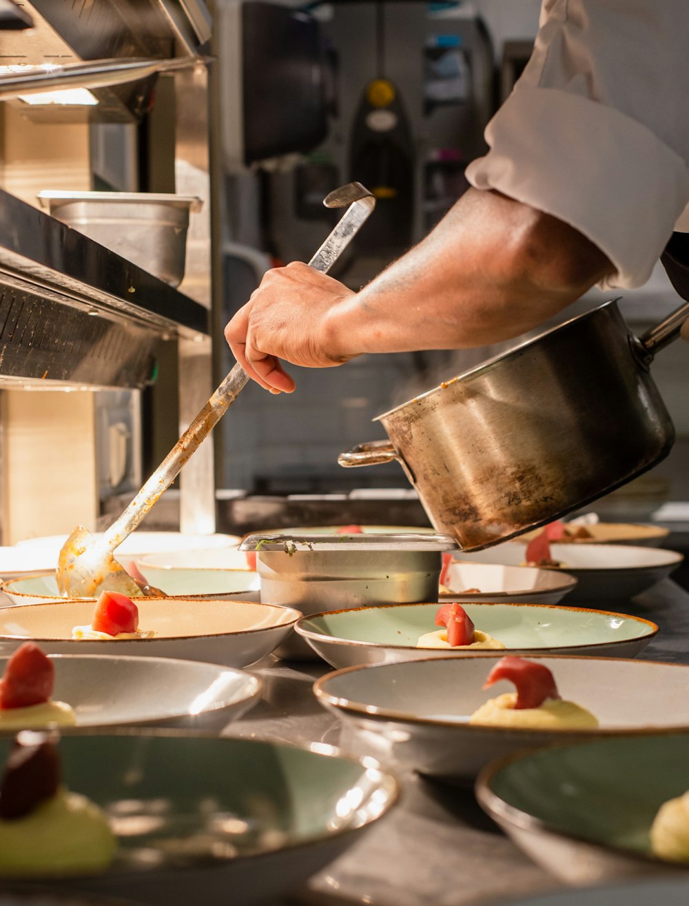 person holding pot and ladle by dishes