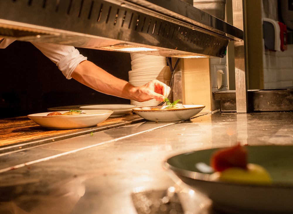 person putting mint on top of dish