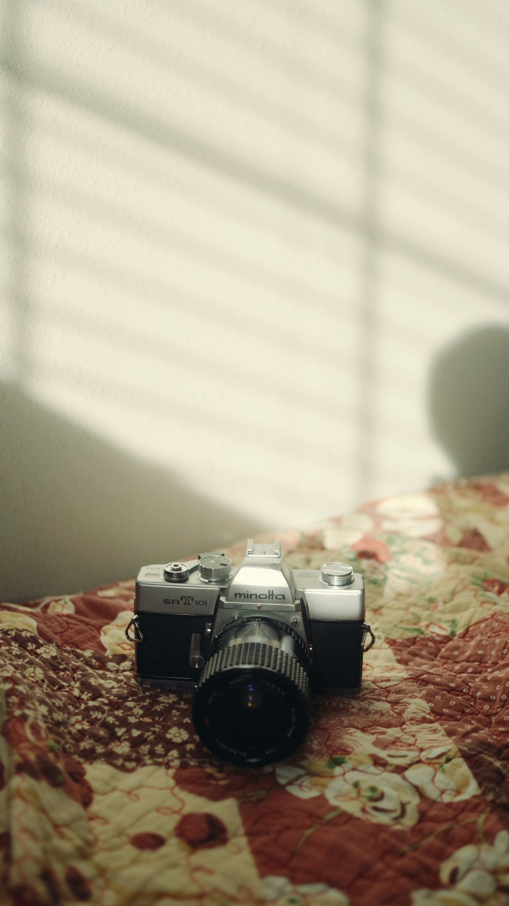 a camera sitting on top of a bed next to a window