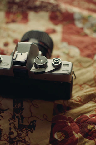 A close-up shot of a vintage camera resting on a luxurious velvet fabric with golden accents.