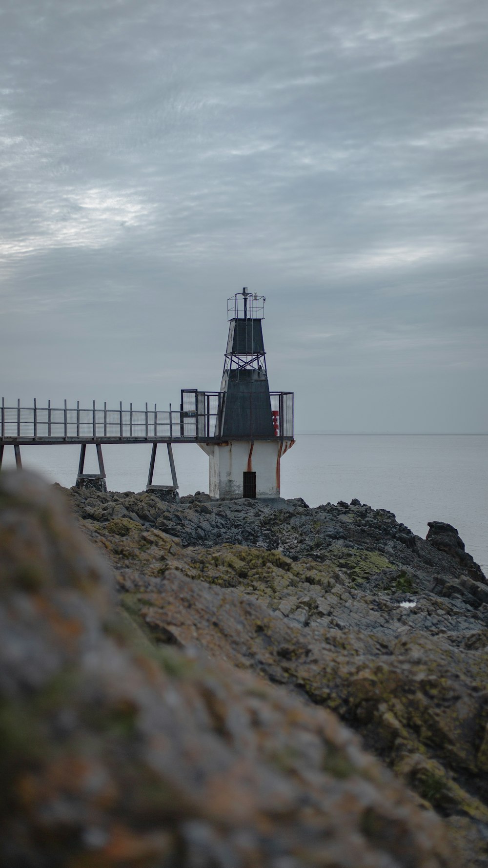 lighthouse on rocks at daytime