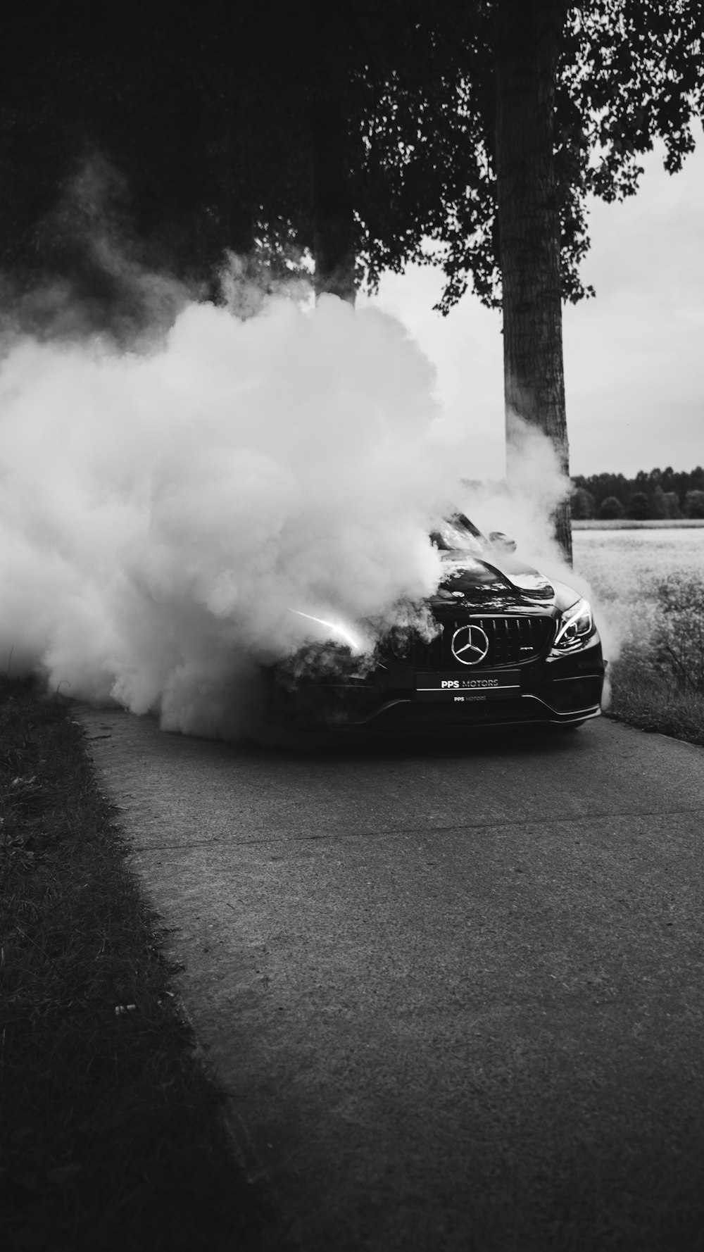 Mercedes-Benz on road covered with smoke during daytime