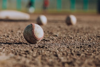 selective focus photography of white baseball balls on ground