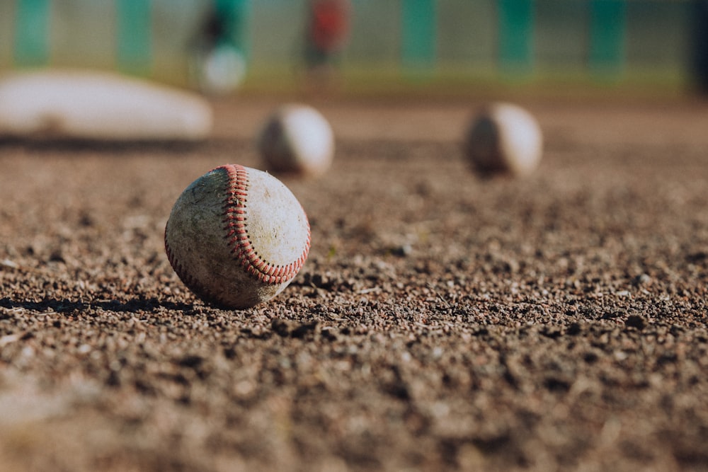 Fotografía de enfoque selectivo de pelotas de béisbol blancas en el suelo