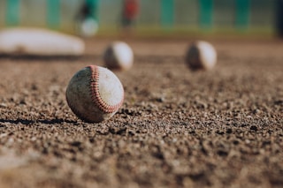 selective focus photography of white baseball balls on ground