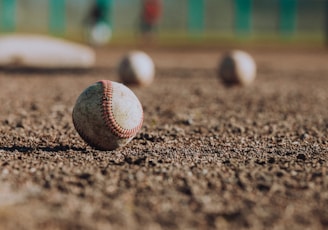 selective focus photography of white baseball balls on ground