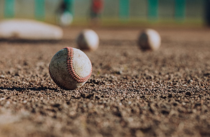 selective focus photography of white baseball balls on ground