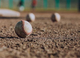 selective focus photography of white baseball balls on ground