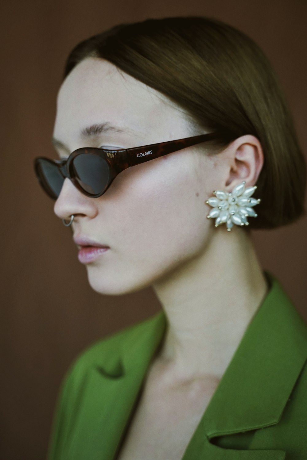 woman wearing green notched lapel suit jacket and sunglasses