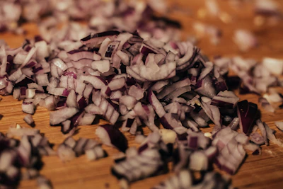 Bright, finely ground onion powder displayed in a small bowl with some scattered around.