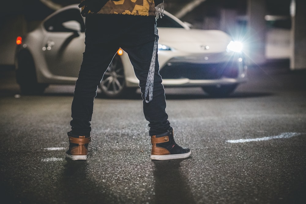 man wearing black-and-yellow Air Jordan 1's while standing on parking space  in front of white Toyota 86 photo – Free Grey Image on Unsplash