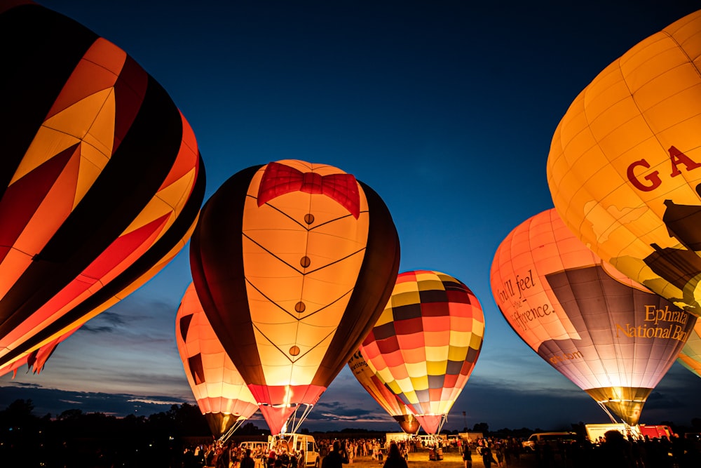 people watching hot air balloons during night time