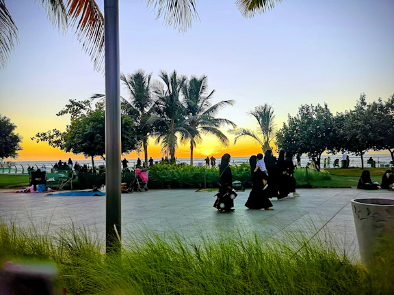 A vibrant group of kingdompath members gathered in prayer outdoors at sunset.