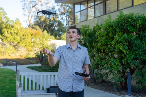Young girl piloting a drone with an instructor guiding her outdoors.